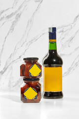 Baba preserving jars and borsci elixir bottle displayed on white marble surface