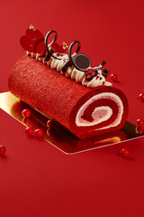 Red velvet roll cake decorated with chocolate hearts and currants for valentine's day