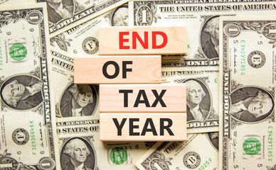 End of tax year symbol. Concept words phrase End of tax year on beautiful wooden blocks. Dollar...