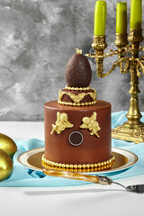 Chocolate easter cake decorated with golden angels and chocolate egg