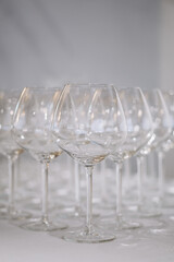 A row of elegant empty wine glasses sparkles in soft focus, creating a refined and festive atmosphere