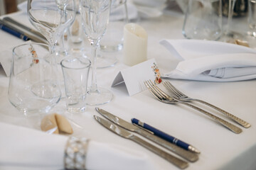 Elegant wedding banquet table decorated with white florals, glassware, and folded napkins for a sophisticated celebration.