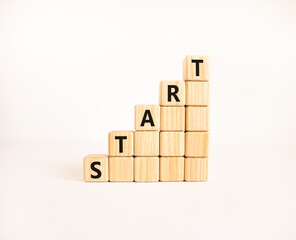 Start symbol. Concept word Start on beautiful wooden blocks. Beautiful white table white...