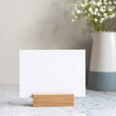 A blank mock up white card in a wooden holder on a minimalist home kitchen background.
