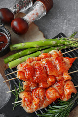 Marinated chicken kebab. Raw chicken breast kebab. Raw sliced chicken breast on wooden sticks with asparagus
