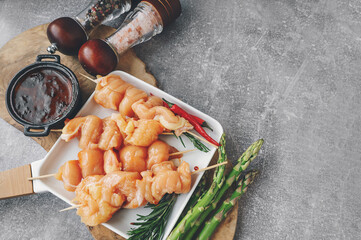 Raw chicken breast kebab. Raw sliced chicken breast on wooden sticks with asparagus and spices