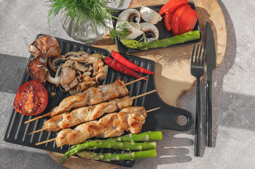 Barbecue on bamboo sticks. Grilled chicken kebab with mushrooms, asparagus and tomato. Red hot kebab.