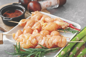 Raw chicken breast kebab. Raw sliced chicken breast on wooden sticks with asparagus and spices