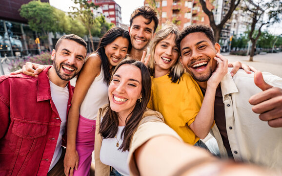 Multicultural cheerful friends taking selfie pic with smart mobile phone device - Youth community people laughing at camera together - Friendship concept with guys and girls having fun outdoors