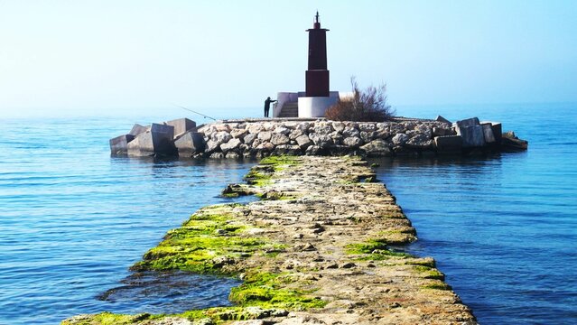 Serene coastal lighthouse and pier scene.