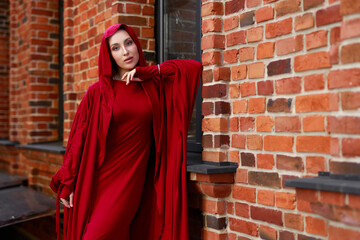 beautiful islamic woman in national dress walking against brick wall	
