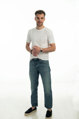 Fototapeta premium Confident young man standing against isolated white background