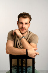 Portrait of young man sitting against isolated background