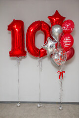 red foil numbers 10 and set of red and silver helium balloons for the party