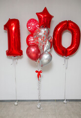 red foil numbers 10 and set of red and silver helium balloons for the party
