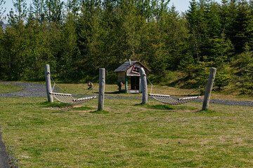 Wooden hammocks and playhouse in Mosfellsbær Iceland surrounded by lush green forest