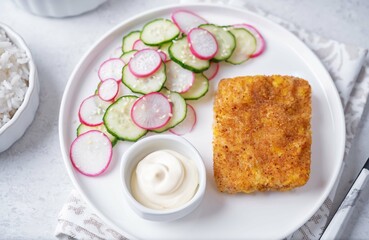Fried pollock fish with cream sauce and cucumber and radish salad