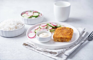 Fried pollock fish with cream sauce and cucumber and radish salad