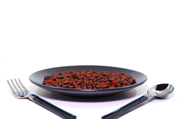 Coffee beans on black plate with cutlery set together with white background closeup view selective focused 