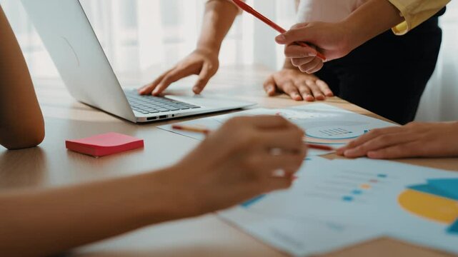 Startup company employee working together using laptop analyzing BI dashboard paper on financial data report and planning strategic marketing for creative business success in panorama video. Synergic - Powered by Adobe