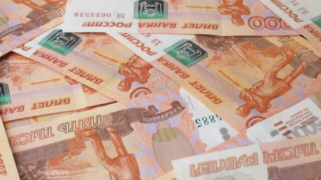 Close-up of the Bank of Russia banknotes with a face value of five thousand rubles, rotating in a circle. Background with Russian paper money. The concept of finance, inflation and sanctions.