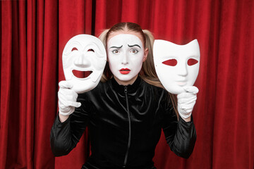 Portrait of a mime girl with masks in her hands