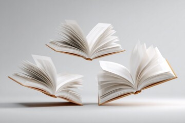 Fototapeta premium Three open books hover above a light surface, pages fanned out as if caught in a breeze, symbolizing the joy of reading
