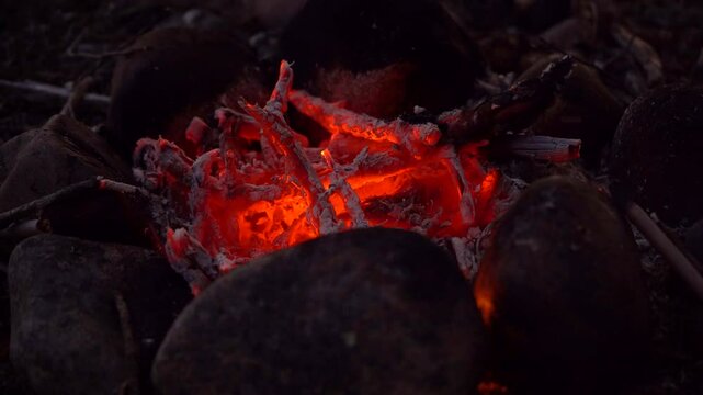  red coals of the fire burn in the night.