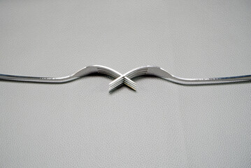 Silver forks combine together placed on grey leather mattress background close-up view flat lay...