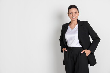 Confident business woman in suit on light background. Space for text