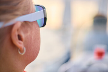 A girl looks at the regatta through sunglasses