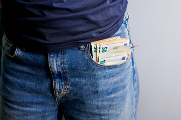 Cash tucked away in pocket of denim jeans, capturing a moment of everyday life in a casual setting