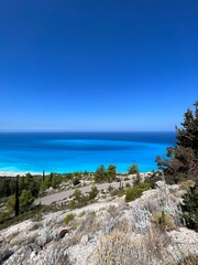 Blue sea and cliffside with trees