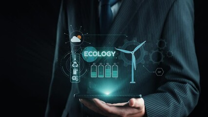 A businessman presents an interactive tablet showing ecology-themed graphics, including a wind turbine and battery icons, symbolizing sustainable energy and innovation. Qubit - Powered by Adobe