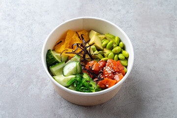 Colors burst from a beautifully arranged poke bowl featuring diced salmon, seaweed, cucumber, avocado, and orange. This delightful mix invites a refreshing taste experience perfect for lunch