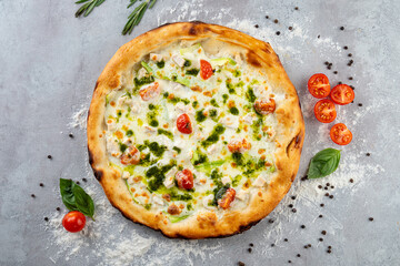 Warm, golden crust surrounds a medley of colorful tomatoes, fresh basil, and a drizzling of green pesto. The rustic table adds charm to this culinary delight