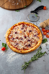 Mouthwatering pizza comes to life with a golden crust, gooey cheese, and vibrant toppings, resting on a textured surface. Fresh herbs surround the dish, enhancing the inviting aroma of the kitchen