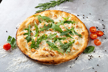 A delicious pizza emerges from the oven, topped with fresh arugula, vibrant cherry tomatoes, and aromatic herbs, creating an inviting culinary masterpiece in a charming kitchen setting