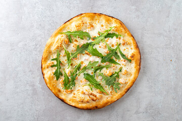 Delight in a freshly baked artisan pizza with a golden crust, generously topped with creamy cheese and vibrant arugula. A culinary masterpiece perfect for sharing