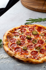 Delicious pepperoni pizza features crispy edges, gooey cheese, and spicy jalapenos, resting on a rustic countertop, inviting anyone to enjoy a slice of culinary delight