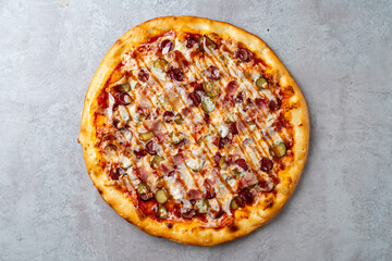 A mouthwatering gourmet pizza features a golden crust generously topped with savory pepperoni, tangy pickles, and melted cheese, presenting a tempting culinary creation