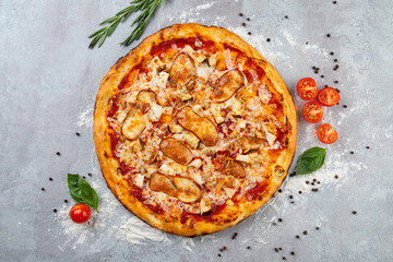 A mouthwatering pizza features succulent chicken pieces, melted cheese, and vibrant veggies arranged artistically. Surrounding herbs and spices add to the culinary charm