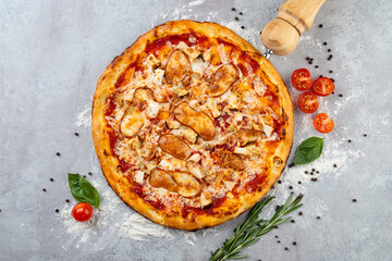 A mouthwatering pizza is presented with a crispy crust, melted cheese, chicken pieces, and fresh toppings