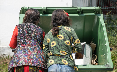 poor people searching in a dumpster