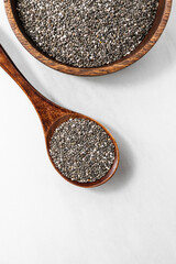 Top view of chia seeds in a wooden bowl with a spoon. Healthy superfood concept, ideal for plant-based, vegan, and clean eating themes.