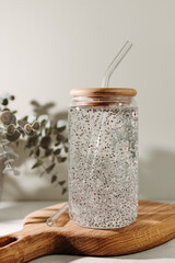 Chia water in a glass on a kitchen wooden board. Healthy detox drink.