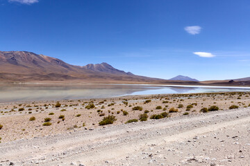 Stunning landscape of Avaroa National Park in Bolivia showcasing unique terrain and a tranquil lake...