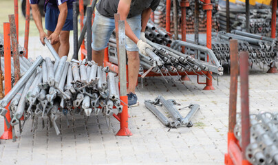 
Workers organizing metal pipes