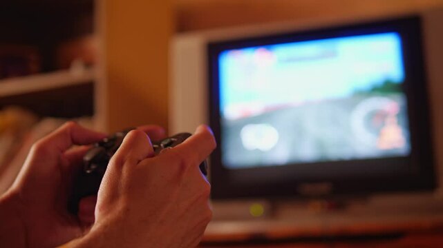 A close-up shot captures an engaged and immersive mood as hands hold a game controller, focused on the screen of an old television displaying a video game, suggesting active play