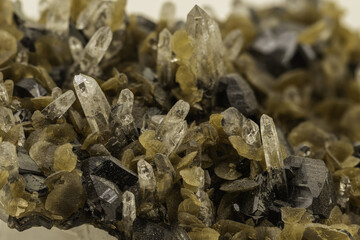 A striking mineral specimen featuring transparent quartz crystals, yellow-green epidote, and black...